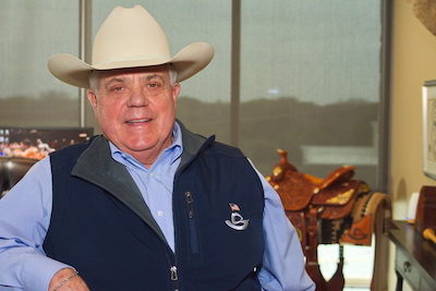 Photo of older man in cowboy hat smiling at camera