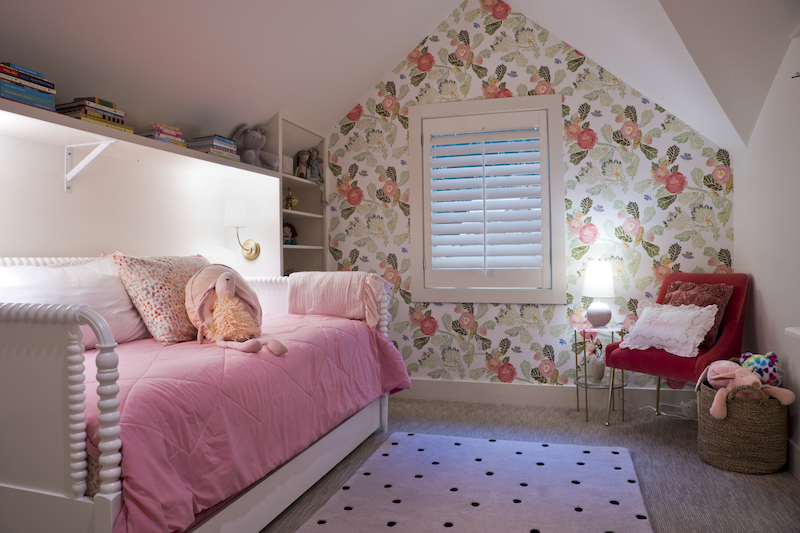 The bright, floral wallpaper was a favorite from her daughter’s room in Stone Oak. Katherine loved the wallpaper and contacted designer Kim Wolfe to order the same paper for the new room. Built around the white barley twist day bed, custom shelves hold books, dolls and mementoes. Brass legged and rose velvet chair from Anthropologie.