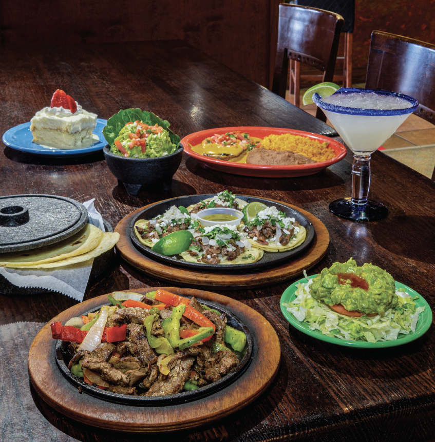 A table filled with American/ Mexican food.