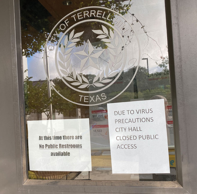 Terrell city hall door with COVID precaution signs